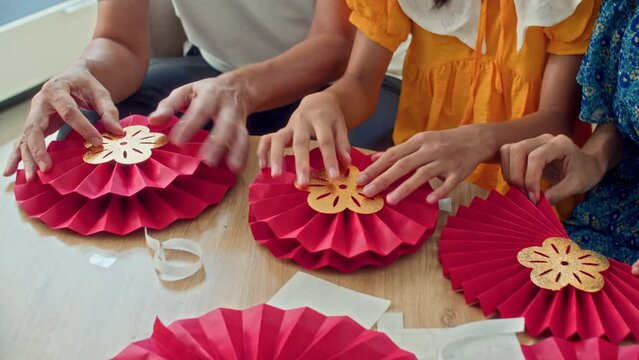 Cropped shot of unrecognizable kid crafting red and yellow decorations preparing for spring festival celebrationCropped shot of unrecognizable kid crafting red and yellow decorations preparing for spr