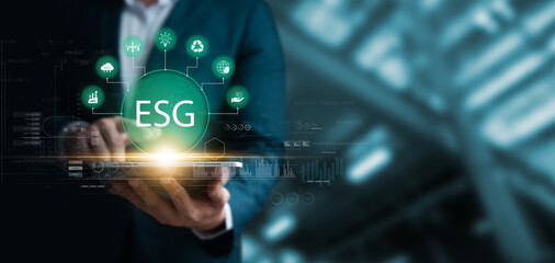 Social investment business concept. ESG and environmental governance, businessman use tablet green ESG icon, sustainable global clean energy, sustainable and ethical corporate development.