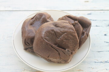 3 pieces of chocolate bread filled with chocolate jam in a white plate on the table