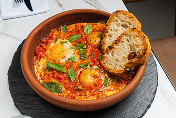 Shakshuka with eggs, tomatoes and bread