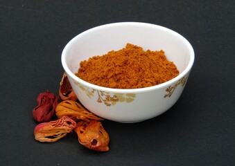 Mace spice powder in a bowl on black background side view 