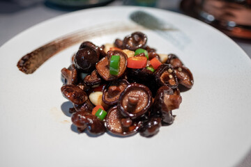 Small braised mushroom with garlic and chili on an artistic plate
