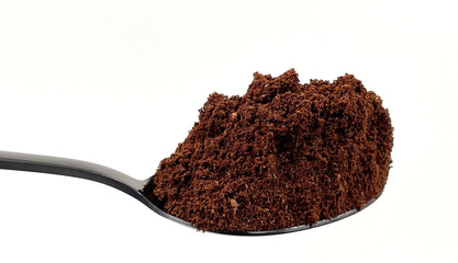 Ground coffee powder in a stainless steel teaspoon isolated on a white background.