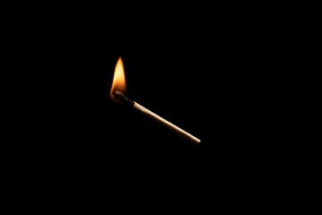 Lit falling match on a black background.