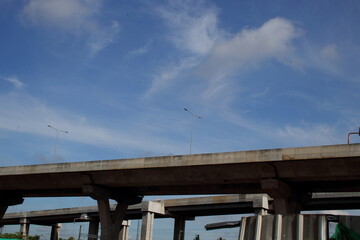 Fototapeta premium Concrete overpass way and blue sky with white clouds in Bangkok, Thailand.