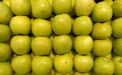 a collection of green apples in a basket