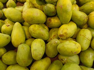 a collection of fresh mangoes in a basket