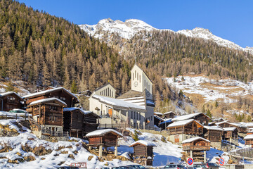 Chalet village Blattenin the Loetschental village with its modern church. The town is well known for keeping clusters of traditional wooden chalets and barns built closely together.