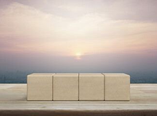 Four block cubes on wooden table over city tower and skyscraper at sunset, vintage style