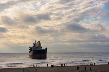 A large cargo sea ship sails on the ocean among the waves