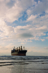 A large cargo sea ship sails on the ocean among the waves