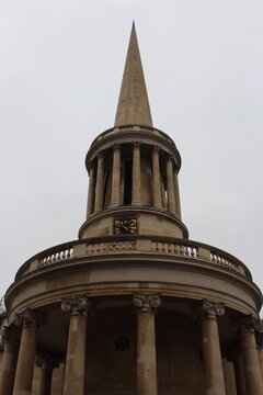 Iconic London Church steeple of All Souls Langham Place, a 19th-century, working evangelical church, designed by John Nash, with an ornate galleried hall. Seen on grey, overcast day. Steeple on gray