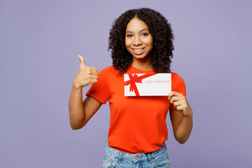 Little kid teen girl of African American ethnicity wear orange t-shirt hold store gift certificate...