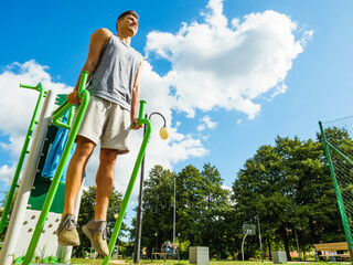 Man doing exercises on the public gym equipment.