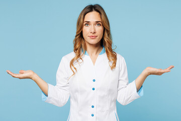 Female doctor woman wearing white medical gown suit work in hospital clinic office spread hands point aside on area look camera isolated on plain blue background studio. Health care medicine concept.