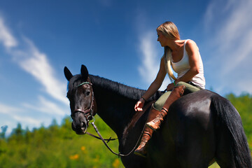 Woman women with horse riding horses on a summer meadow without a saddle.