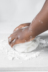 Fototapeta premium Hands kneading white fondant for decorating cake, fondant being mixed on a table