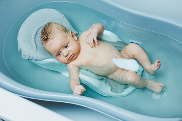 Baby's first baths. Caring for a newborn baby. Bathing a baby in a bathtub