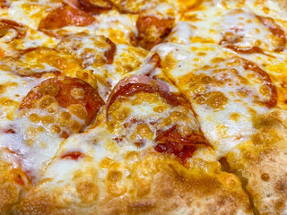 Obraz na płótnie Canvas Hot delicious pizza pepperoni with salami, close-up. Pepperoni pizza with cheese traditional Italy cuisine. 
