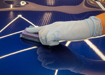Automotive ceramics. Car service worker applying nano coating on a car detail close-up. Closeup of...