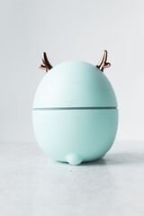 Cute blue deer humidifier with gold antlers on a white background, elk humidifier on a marble counter