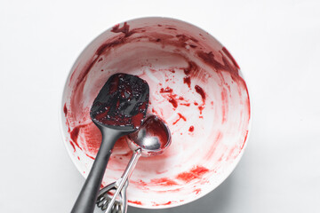 Red velvet cake batter in a bowl that has been scraped clean, Leftover cake batter in a white mixing bowl