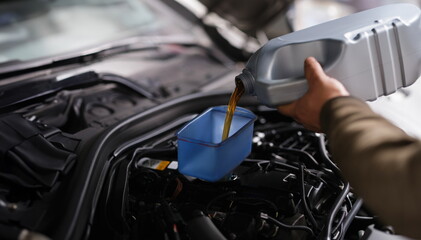 Refueling with fresh engine oil car engine. Auto service concept