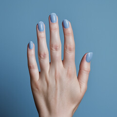 fotografia con detalle de mano femenina con las uñas pintadas con esmalte de tonos azules - obrazy, fototapety, plakaty