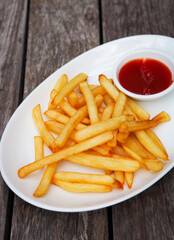 French fries with ketchup on wooden background