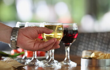 Close-up of male person take glass of alcoholic drink from bar, cooling beverage, champagne or wine. Get drunk, celebrate with drink, cheers, toast concept