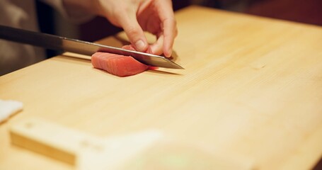 Hands, food and sushi chef cutting fish in restaurant for traditional Japanese cuisine or dish...