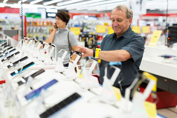 Elderly man chooses smart watch in store