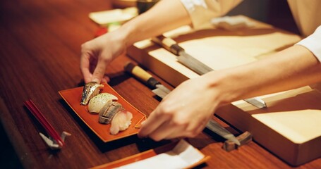 Hands, cooking and chef serving sushi in restaurant for traditional Japanese cuisine or dish...
