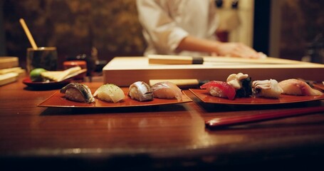 Sushi, plate and serving with chef in restaurant for luxury cuisine or raw meal preparation...