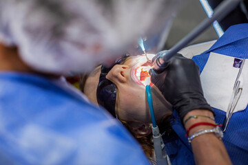 girl at a dentist's appointment with her mouth open. Orthodontist treatment and dental care