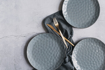 set of grey modern ceramic plates with golden cutlery. Dishware trendy  collection.