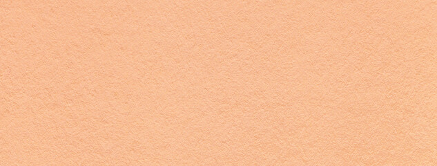 Color of year 2024 peach fuzz. Texture of craft coral paper background, macro. Vintage kraft...