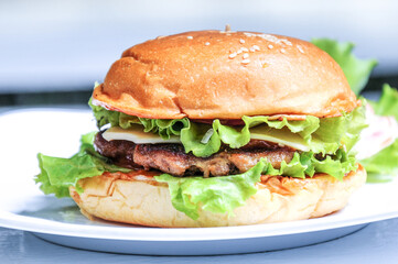 Special beef burger with cheese and lettuce topped with tomato sauce and mayonnaise sauce