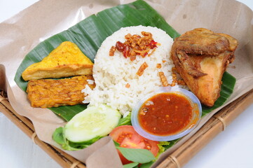 Fried chicken, served with white rice, fried tofu, tempeh and fresh vegetables
