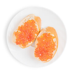 Red salty salmon caviar or fish roe on two sliced loaf of bread or canape with butter on ceramic round plate isolated on white background served for healthy breakfast full of protein and vitamins