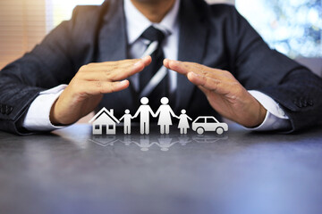 insurance concept with businessman using two hand in protection gesture to family life and property like a car and house represent to ensure and worry free in any activity