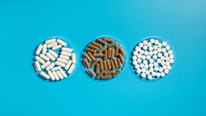 Various vitamins, tablets and dietary supplements on a blue background. Medicine
