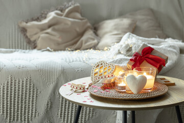 Home composition for Valentine's Day with candles in the interior of the room.