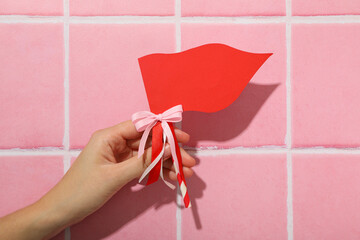 Red flag, accessory for Valentine's Day on a pink background.