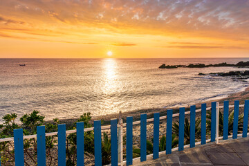 amazing view from a balcony of hotel to a nice sea gulf with beautiful sunrise or sunset, rocks and water with waves.