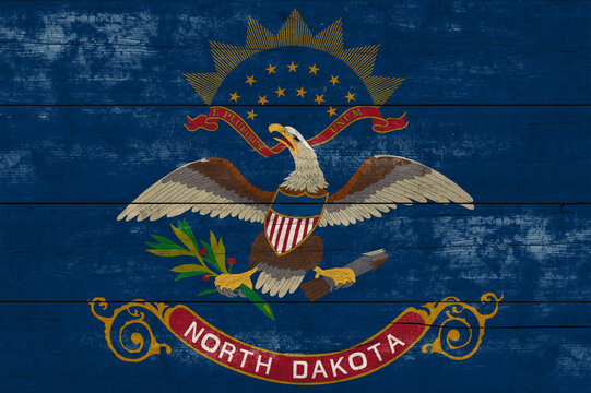 North Dakota State flag on a wooden surface. Banner of the grunge North Dakota State flag.