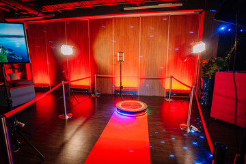  360 spinner photo booth setup with a red carpet and lighting in a venue with red ambient...