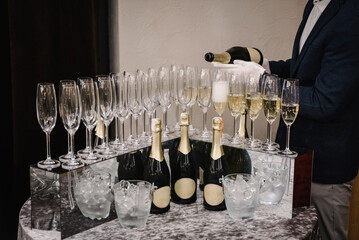 Champaign is being poured into glasses. The waiter pouring white sparkling wine. Catering service...