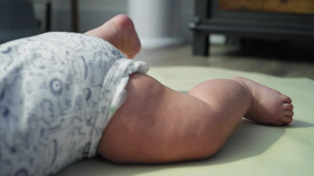 baby boy moves his legs around while attempting to learn how to crawl
