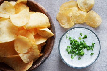 Potato chips with sauce with herbs on a gray background